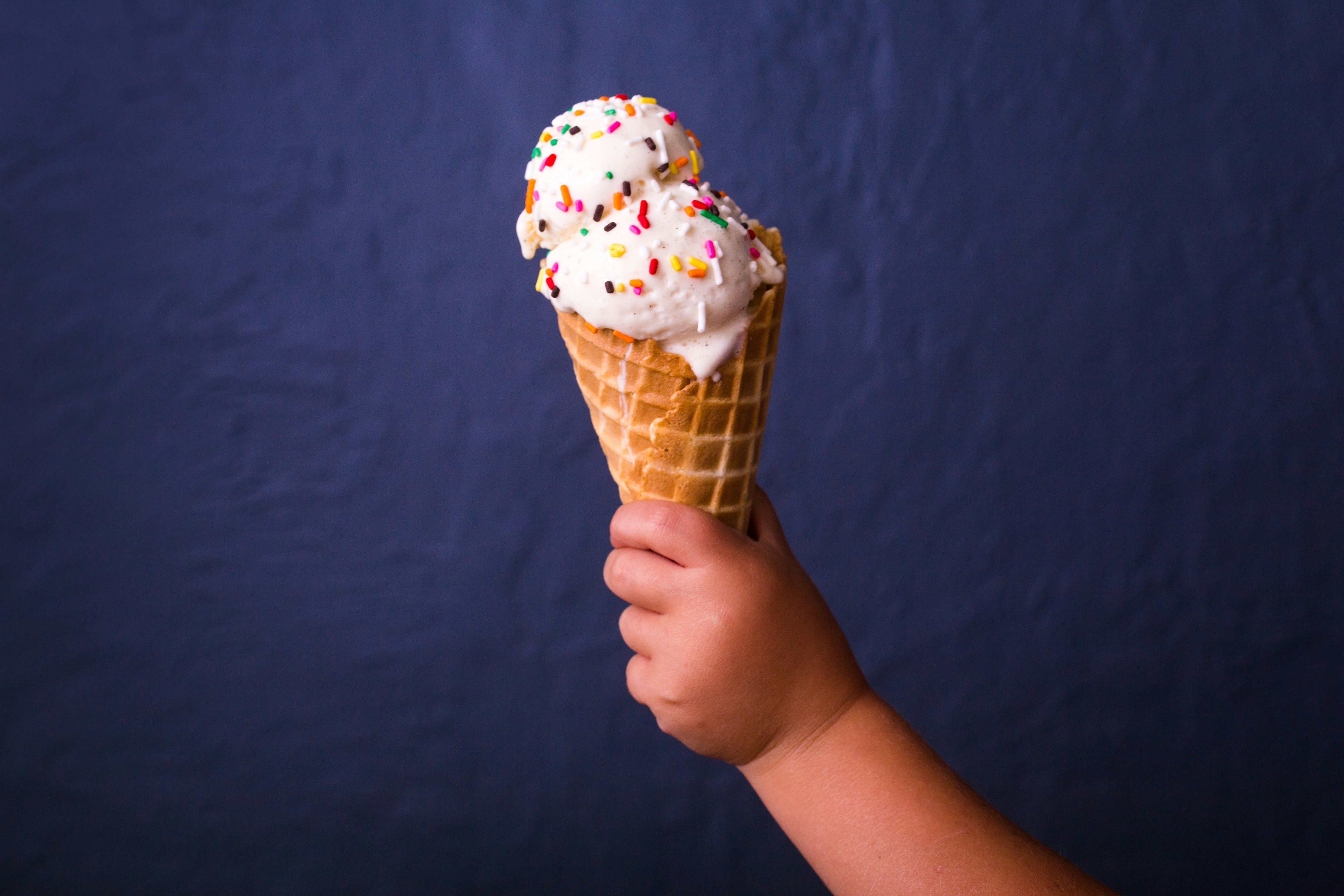 children holding brown ice cream cone with strawberry icecream